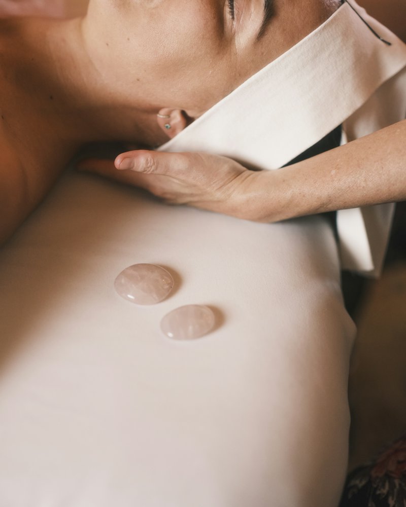 Kỹ thuật viên massage cổ vai cho khách nằm trên khăn trắng