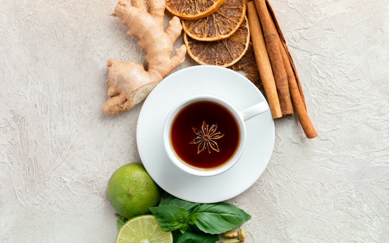 Tách trà thảo mộc bên gừng, quế và cam sấy