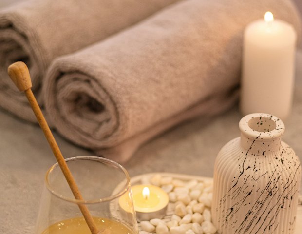 Khăn cuộn, nến và hũ mật ong trên khay đá
