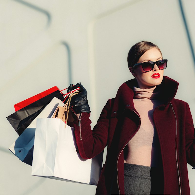 Cô gái đeo kính râm cầm nhiều túi mua sắm